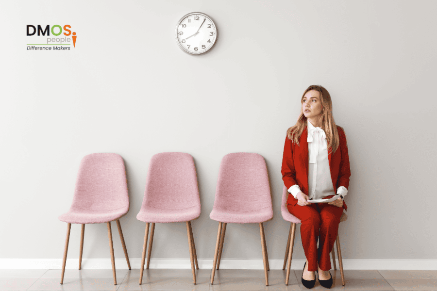 Lady sat on chair next to 3 empty chairs, waiting for her interview