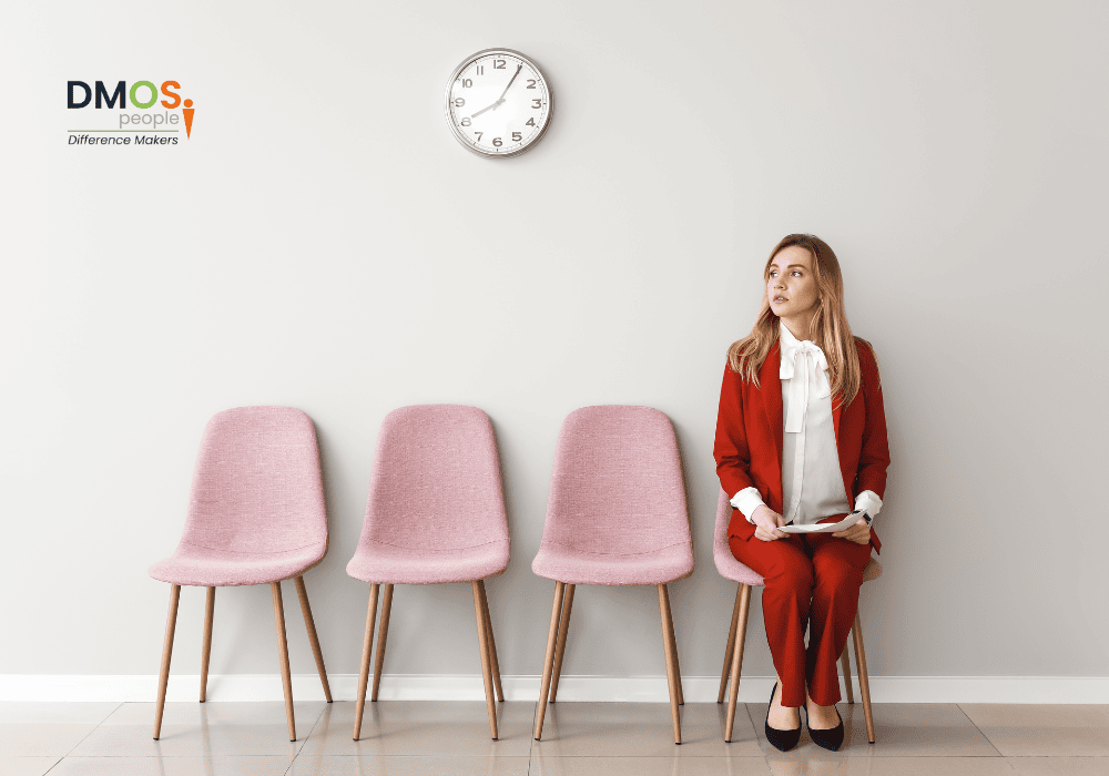 Lady sat on chair next to 3 empty chairs, waiting for her interview